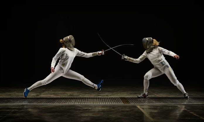 Eskrim, çok eski zamanlardan beri uygulanan bir dövüş sporudur. Klasik anlamda, rakiplerini bir kılıç veya kalkan ile alt etmeye çalışan dövüşçüler arasında geçen bir mücadele türüdür. Ancak günümüzde, eskrim, modern spor formatına dönüştürülmüş ve olimpiyat oyunlarına dahil edilmiştir. Eskrimde, sporcular hız, çeviklik, strateji ve teknik bilgilerini kullanarak rakiplerinin savunmalarını aşmaya çalışır. Eskrim, yalnızca fiziksel güç değil, aynı zamanda zekâ ve strateji gerektiren bir spordur. Hız, denge ve odaklanma gibi özelliklerin gelişmesine katkı sağlarken, rakibin hareketlerini tahmin etme ve doğru anı bekleyerek saldırma yeteneğini de geliştirir. Konulu bir haber görseli.